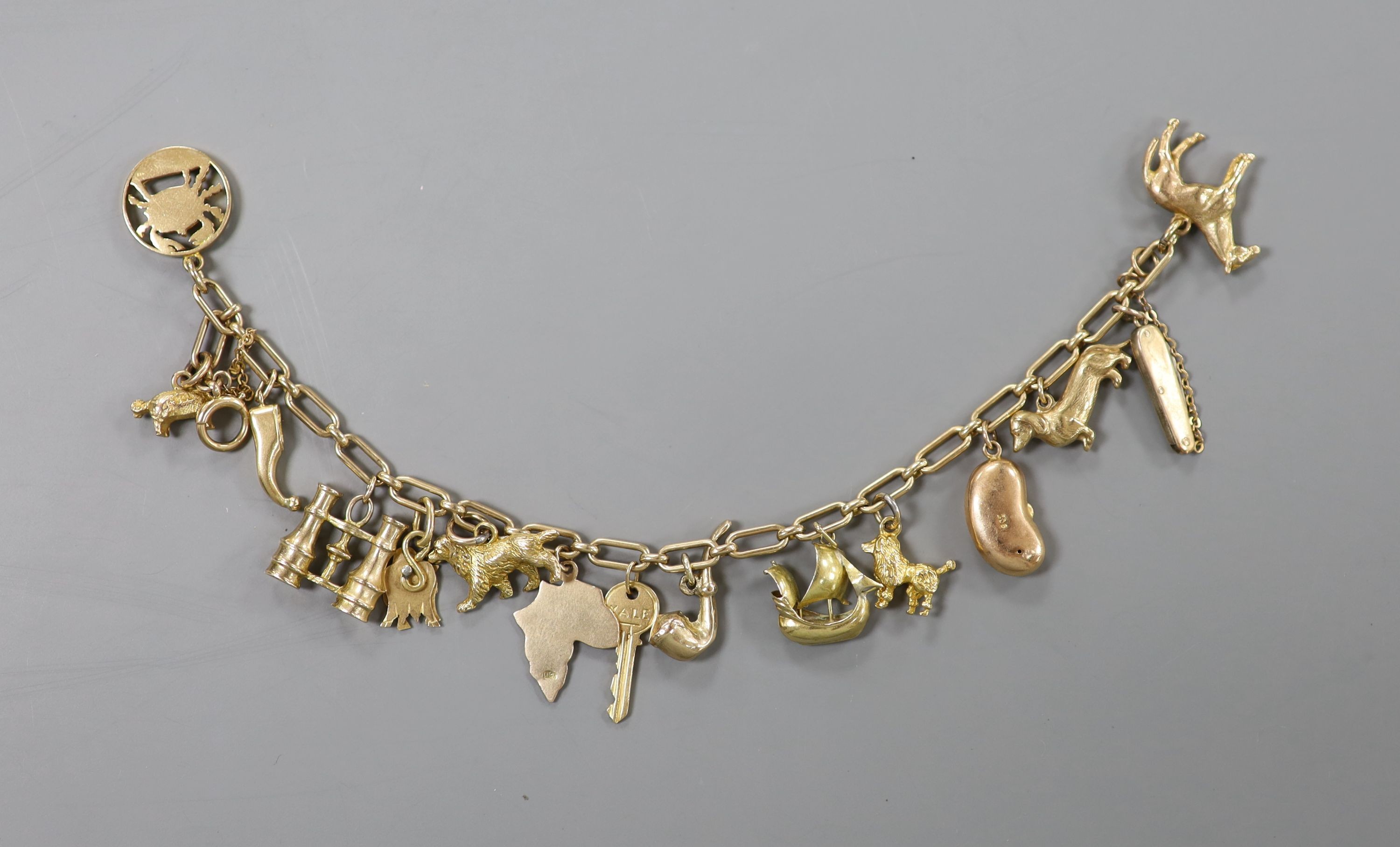 A 9ct oval link charm bracelet, hung with assorted mainly 9ct gold charms, gross weight 31.5 grams.